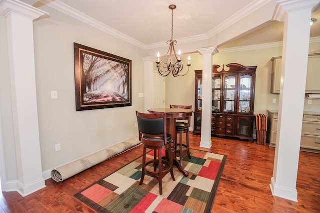 dining space with crown molding, a chandelier, ornate columns, and dark hardwood / wood-style floors