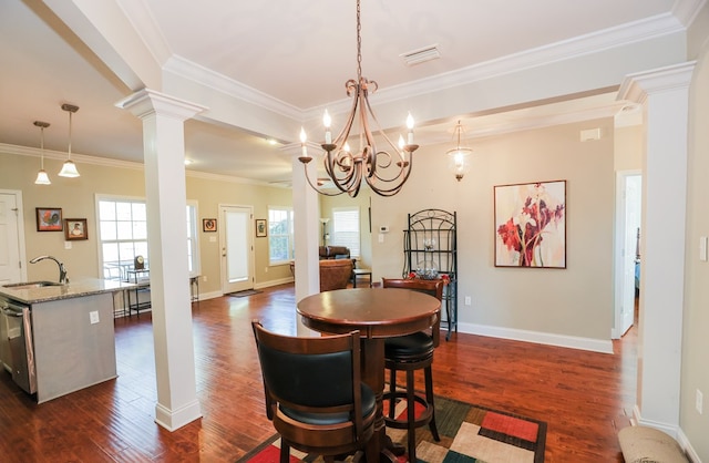 dining area featuring ornamental molding, sink, dark wood-type flooring, and ornate columns