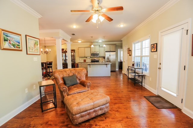 living room featuring ceiling fan with notable chandelier, crown molding, decorative columns, and dark hardwood / wood-style floors