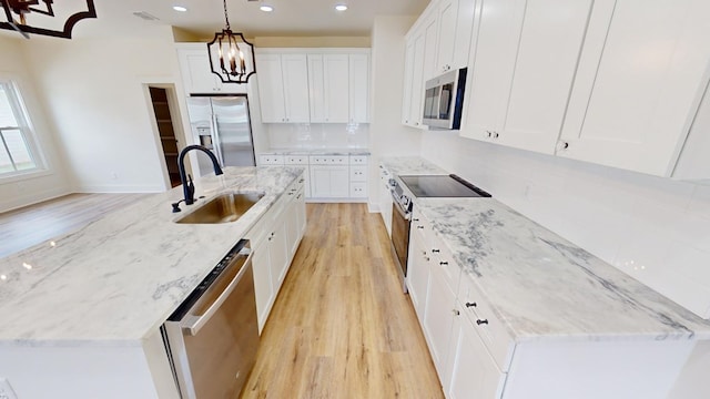 kitchen featuring pendant lighting, sink, stainless steel appliances, tasteful backsplash, and white cabinets