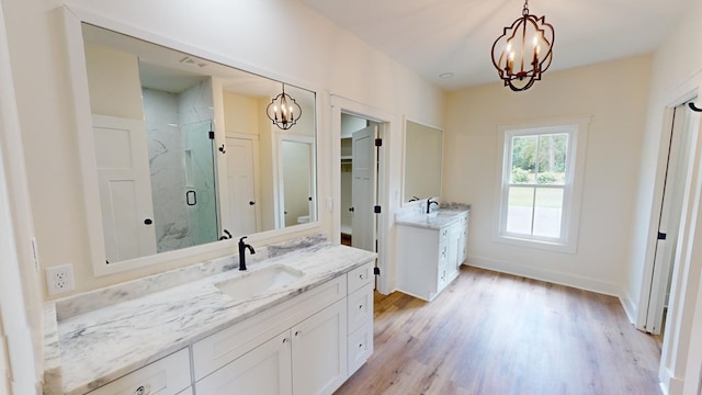 bathroom with hardwood / wood-style flooring, vanity, a notable chandelier, and an enclosed shower