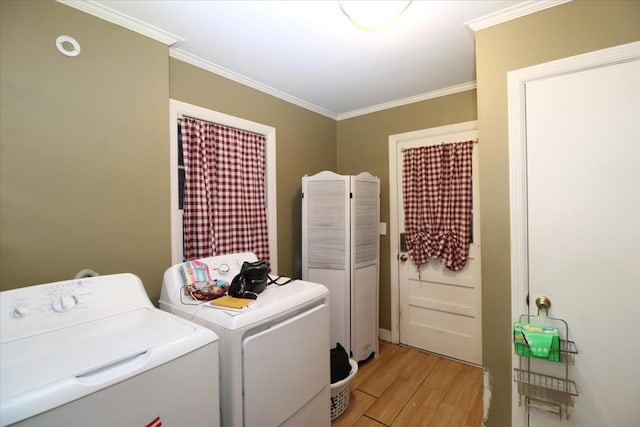 clothes washing area with crown molding, separate washer and dryer, and light hardwood / wood-style flooring