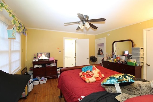 bedroom featuring dark wood-type flooring, ceiling fan, and ornamental molding