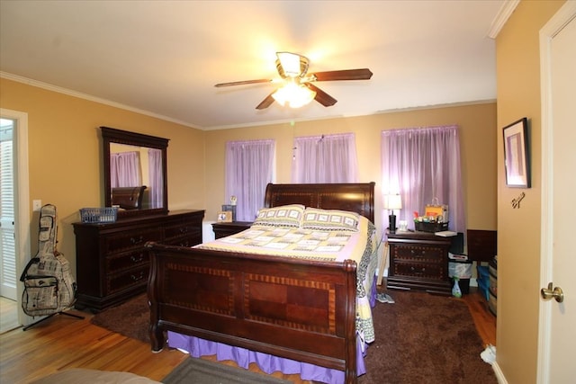 bedroom with hardwood / wood-style floors, crown molding, and ceiling fan