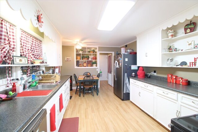 kitchen with crown molding, stainless steel refrigerator, white cabinets, and light hardwood / wood-style floors