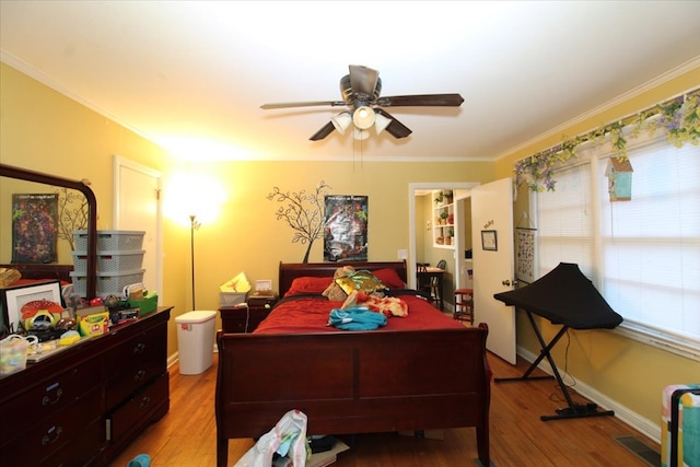 bedroom with ceiling fan, ornamental molding, and light wood-type flooring