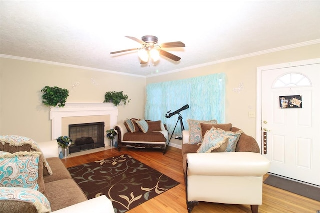 living room featuring hardwood / wood-style flooring, crown molding, and ceiling fan