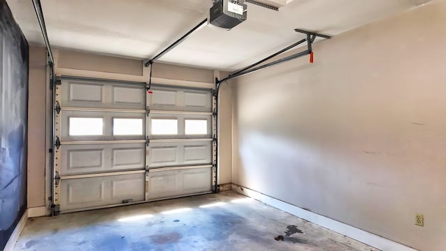 garage featuring a garage door opener and baseboards