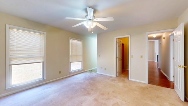 unfurnished bedroom featuring baseboards, light carpet, and ceiling fan