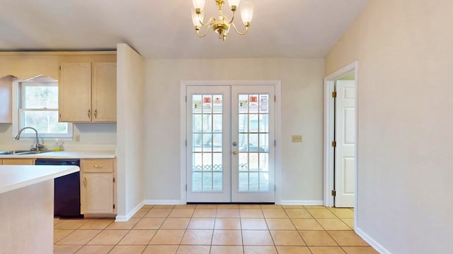 entryway with a notable chandelier, a sink, french doors, light tile patterned floors, and baseboards