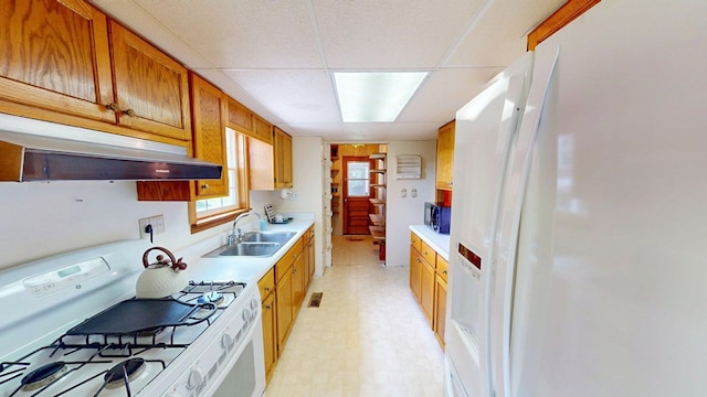 2001 Redfearn St, Barwick, GA 31720 - kitchen featuring white appliances, light countertops, under cabinet range hood, light floors, and brown cabinets