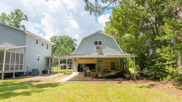 2001 Redfearn St, Barwick, GA 31720 - rear view of house featuring a gambrel roof, a garage, a lawn, a patio area, and a sunroom