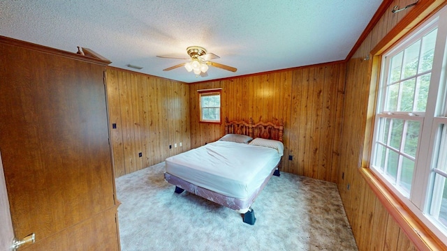 2001 Redfearn St, Barwick, GA 31720 - bedroom with a textured ceiling, wooden walls, carpet, a ceiling fan, and crown molding