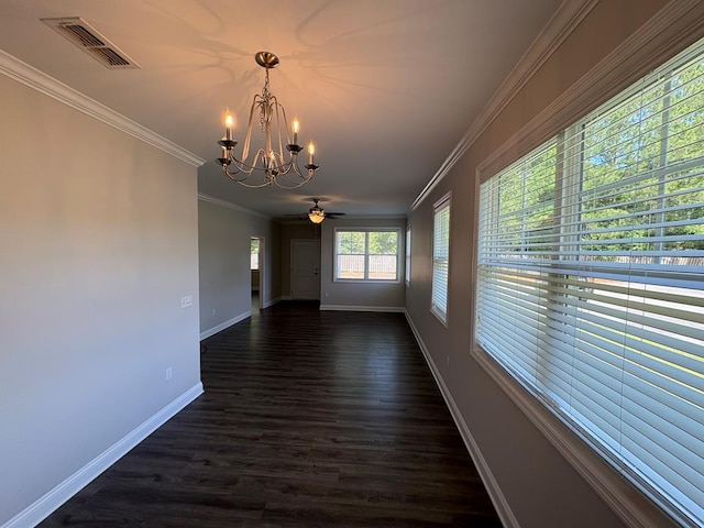unfurnished dining area with a chandelier, baseboards, dark wood-type flooring, ornamental molding, and ceiling fan