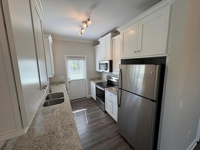kitchen with appliances with stainless steel finishes, a sink, crown molding, white cabinetry, and dark wood-type flooring