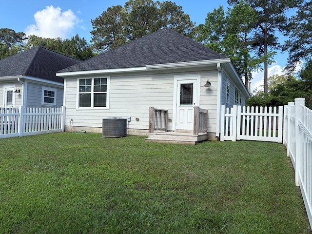 back of house with roof with shingles and central AC