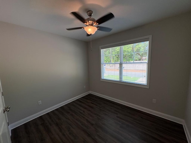empty room featuring dark wood-style flooring, baseboards, and ceiling fan