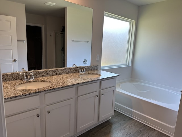 bathroom with vanity, hardwood / wood-style floors, and plus walk in shower