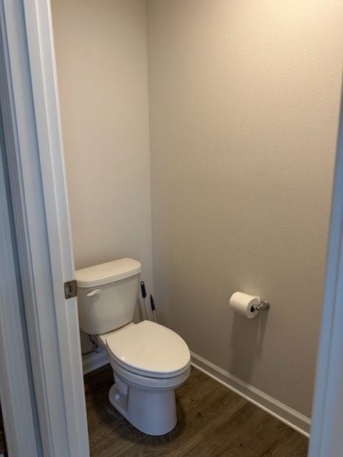 bathroom with hardwood / wood-style flooring and toilet