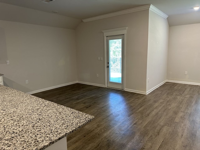 unfurnished room featuring dark wood-type flooring, ornamental molding, and vaulted ceiling