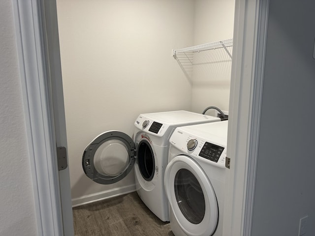 laundry room with dark wood-type flooring and washing machine and dryer