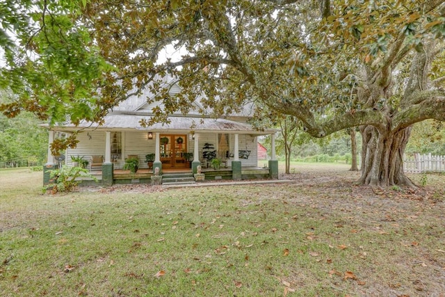 view of front of home featuring french doors, covered porch, and a front lawn