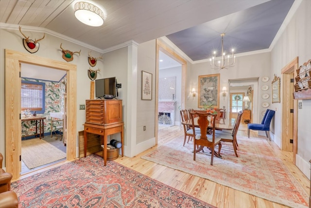 dining room featuring an inviting chandelier, crown molding, and light hardwood / wood-style floors