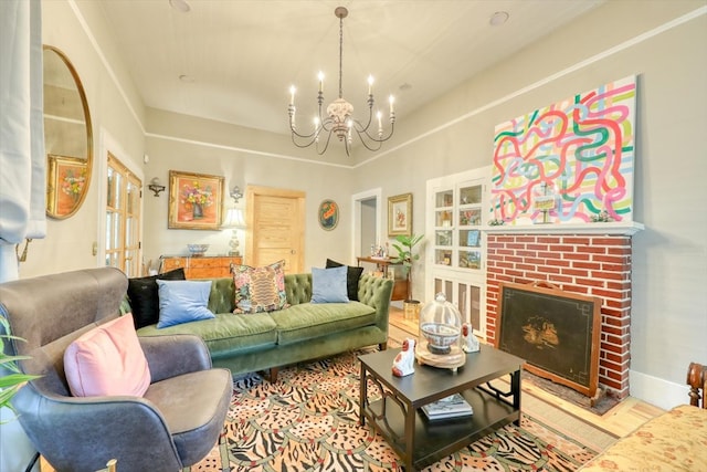 living room featuring an inviting chandelier and a brick fireplace