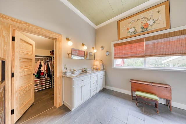 bathroom featuring vanity, vaulted ceiling, and ornamental molding