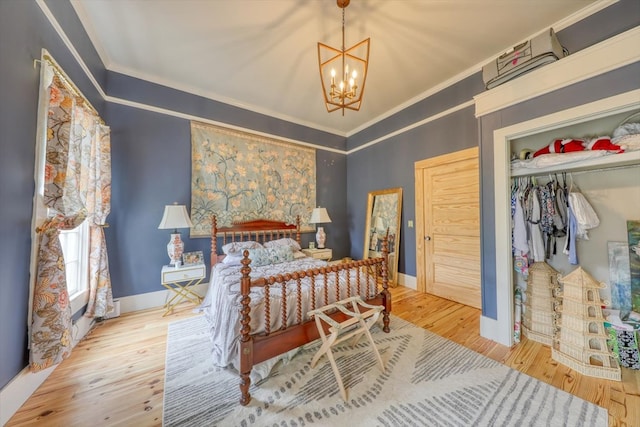 bedroom with crown molding, a notable chandelier, a closet, and hardwood / wood-style flooring