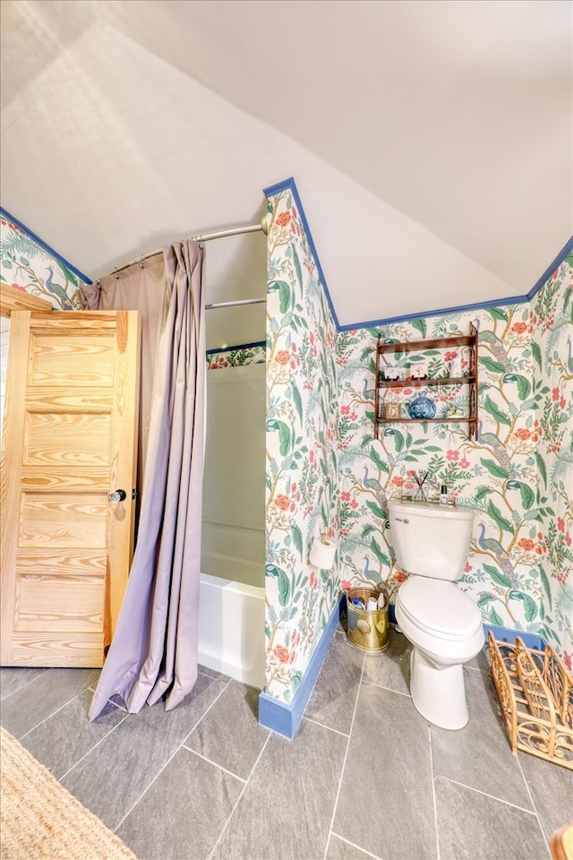 bathroom featuring lofted ceiling, tile patterned flooring, toilet, and shower / bath combo