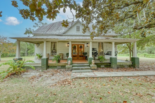 farmhouse inspired home featuring covered porch and french doors