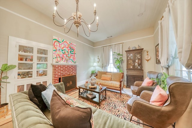 living room featuring wood-type flooring, a fireplace, and a chandelier