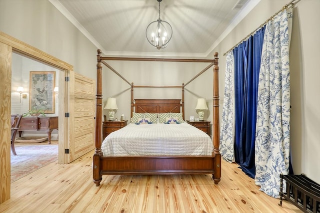 bedroom with ornamental molding, light hardwood / wood-style floors, and a chandelier