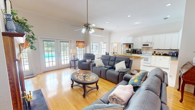 living room with ornamental molding, ceiling fan, light hardwood / wood-style floors, and french doors