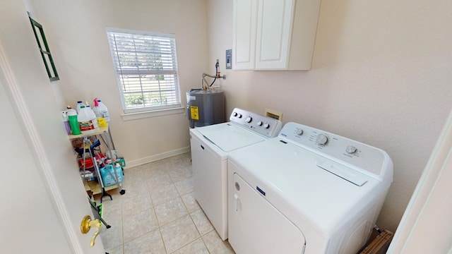 laundry area with cabinets, light tile patterned floors, water heater, and washing machine and clothes dryer