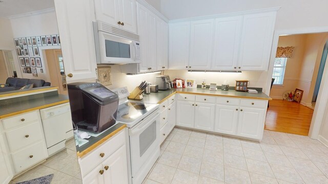 kitchen with light tile patterned floors, white cabinets, and white appliances