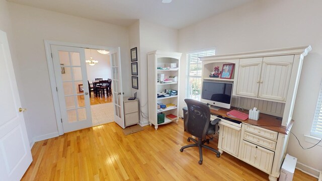 home office featuring a chandelier and light hardwood / wood-style flooring