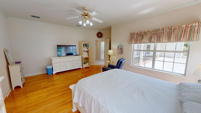 bedroom featuring hardwood / wood-style flooring, ceiling fan, and ornamental molding