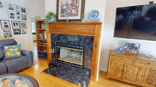 living room with a tile fireplace and light hardwood / wood-style floors