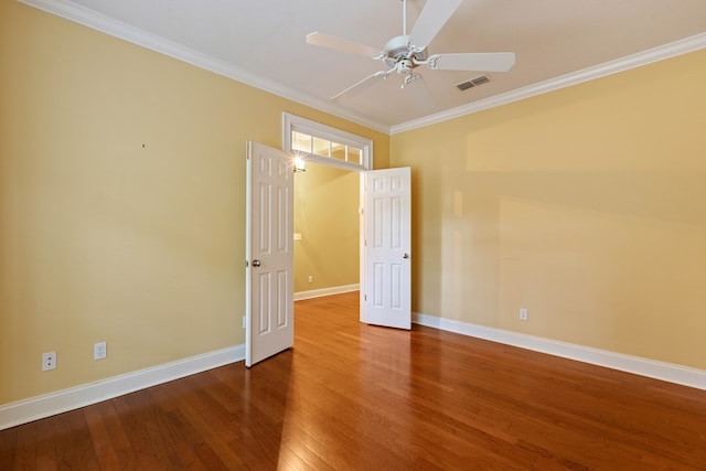 spare room featuring hardwood / wood-style floors, ornamental molding, and ceiling fan