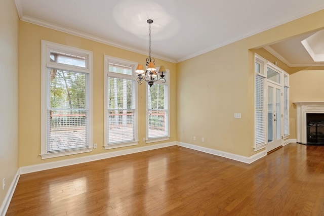 unfurnished dining area featuring a wealth of natural light, ornamental molding, hardwood / wood-style floors, and a notable chandelier