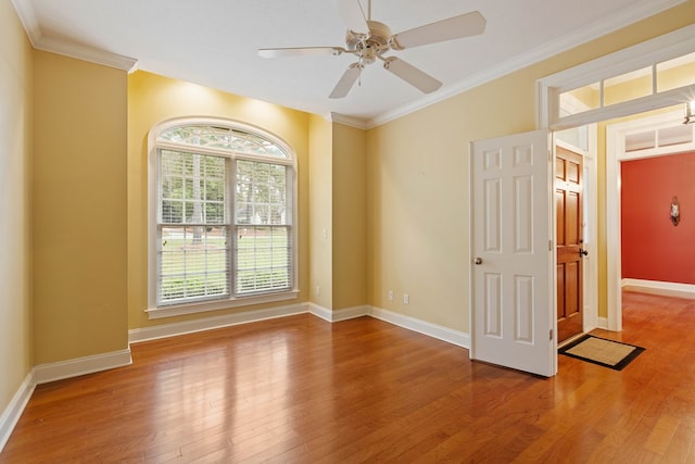 empty room with hardwood / wood-style floors, ornamental molding, and ceiling fan