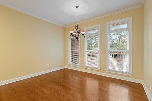 unfurnished dining area with crown molding, hardwood / wood-style flooring, and a chandelier