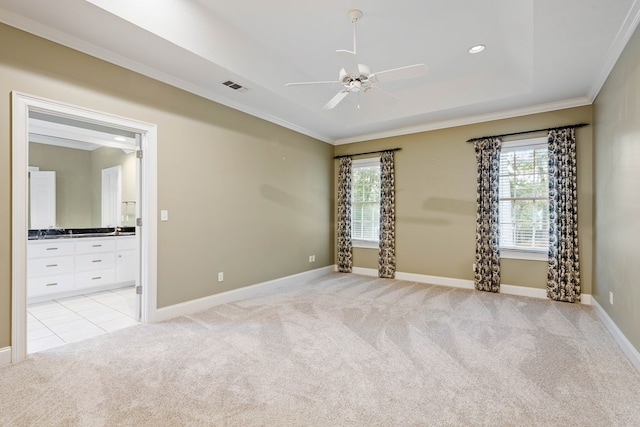 carpeted empty room with crown molding, a wealth of natural light, ceiling fan, and a tray ceiling