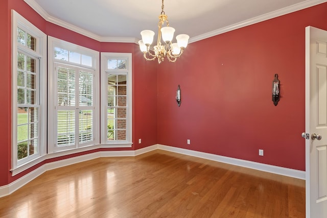 unfurnished dining area with ornamental molding, a chandelier, and hardwood / wood-style floors