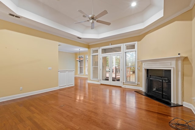 unfurnished living room featuring hardwood / wood-style floors, a raised ceiling, ceiling fan, and french doors