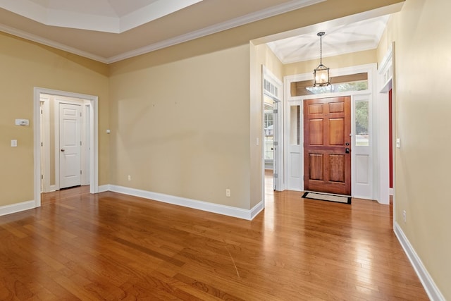 entryway with crown molding, wood-type flooring, and a notable chandelier