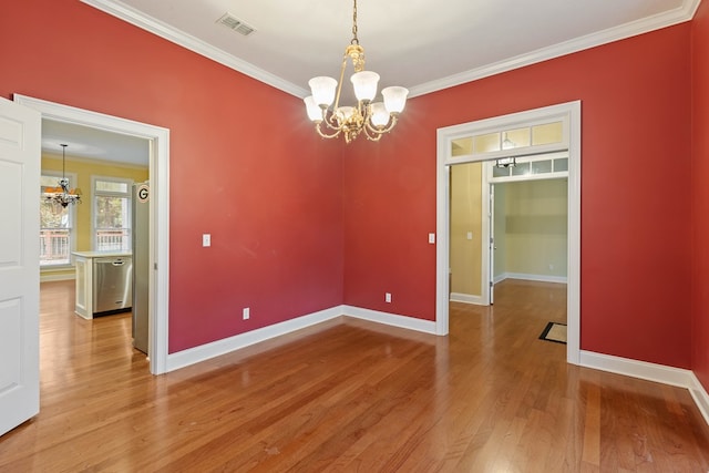 empty room featuring crown molding, hardwood / wood-style floors, and a notable chandelier