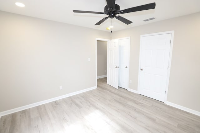 unfurnished bedroom featuring two closets, ceiling fan, and light wood-type flooring